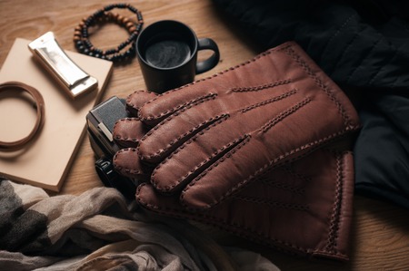 Pair of men's brown leather gloves and other men's accessories.