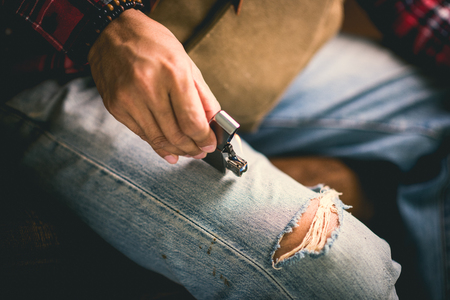 A man holding the burning brushed chrome lighter with windproof.