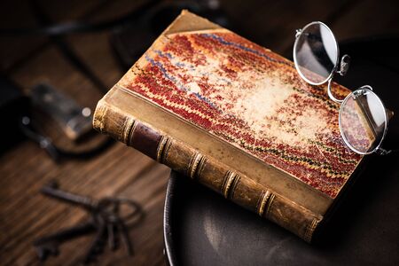 antique leather bound book with marbling paper cover on the table.の写真素材