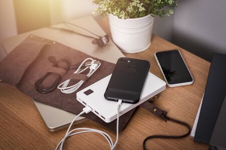 Charging the empty battery smartphone with white power bank.