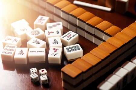 Many old mahjong tiles on wooden table. Mahjong is the ancient asian board game.