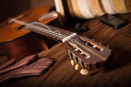 vintage classical guitar with broken string on the sofa.