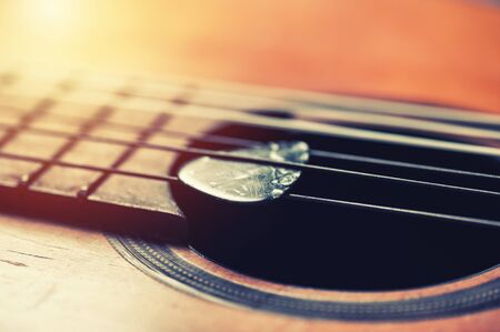 Closeup guitar pick on an old classical guitar. A guitar pick is a plectrum used for guitars.