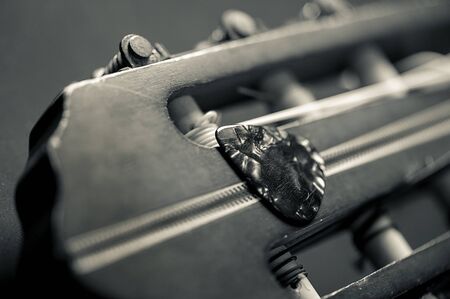 Closeup guitar pick on an old classical guitar. A guitar pick is a plectrum used for guitars.の写真素材