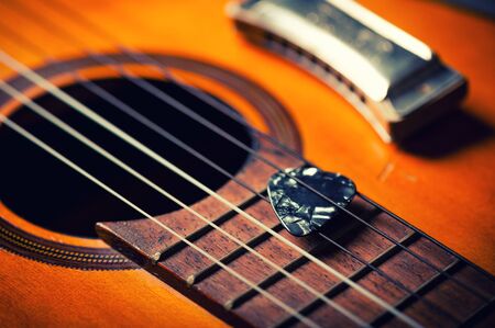 Closeup guitar pick on an old classical guitar. A guitar pick is a plectrum used for guitars.