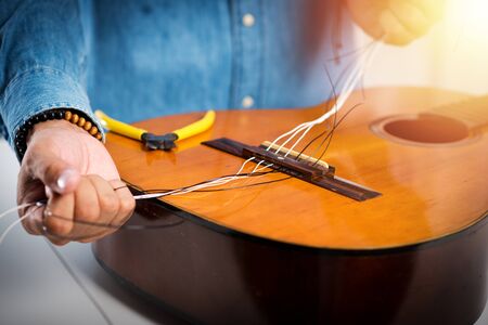 Restring classical guitar concept. The man restring his classical guitar.の写真素材