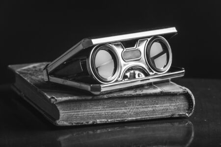Closeup vintage folding opera glasses. Old compact binoculars.の写真素材