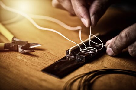 Restring classical guitar concept. The man restring his classical guitar.の写真素材