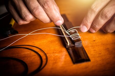 Restring classical guitar concept. The man restring his classical guitar.の写真素材