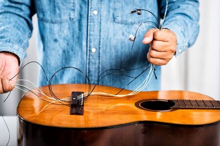 Restring classical guitar concept. The man restring his classical guitar.の写真素材