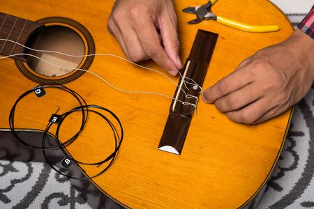Restring classical guitar concept. The man restring his classical guitar.の写真素材