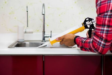 The man applying silicone sealant. The man fixing home.の写真素材