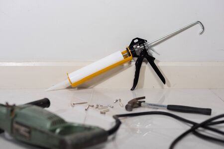 white silicone sealant cartridge and yellow-black sealant gunの写真素材