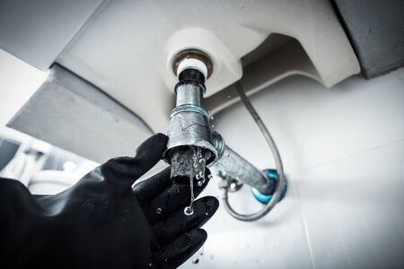 Repairing clogged and leaky washbasin sewer in the bathroomの写真素材