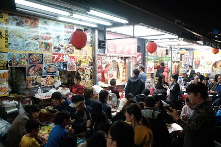 TOKYO, JAPAN - OCTOBER 21, 2018: Many peoples eating street food at Ameyoko market in Ueno, Japan....