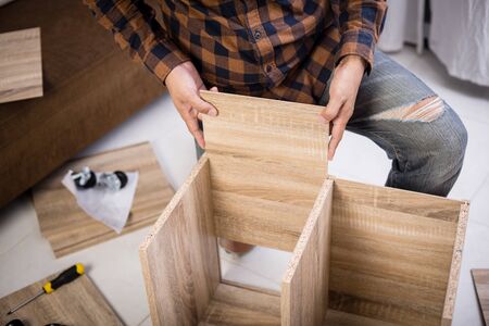 The man assembling new furniture at his home.