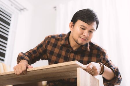 The man assembling new furniture at his home.
