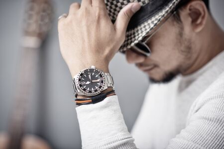 closeup luxury men watch with black dial and stainless steel bracelet on wrist of man.の写真素材