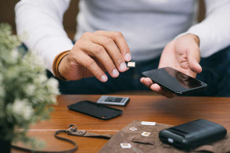 SIM card for smart phone. The man changing the SIM card.