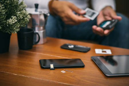 SIM card for smart phone. The man changing the SIM card.の写真素材