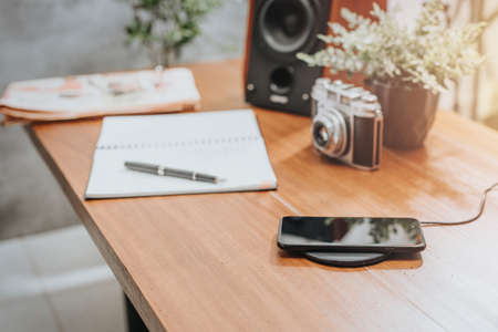 Charging the smartphone with wireless charger on desktop.の写真素材