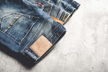many blue jeans on concrete background. men fashion denim jeans.