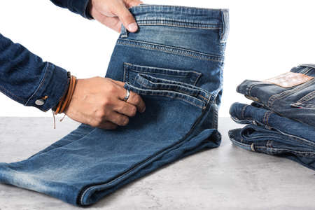 closeup blue jeans in man hand over white background.の写真素材