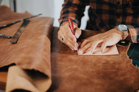 The man working with genuine leather in workshop.の写真素材