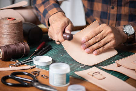 The man working with genuine leather in workshop.の写真素材