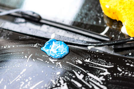 Washing the black car. Car cleaning and car care concept.
