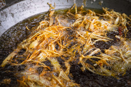 Frying shredded taro in hot oil. Cooking crispy shredded taro, vegetarian food.の写真素材
