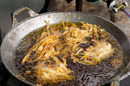 Frying shredded taro in hot oil. Cooking crispy shredded taro, vegetarian food.の写真素材