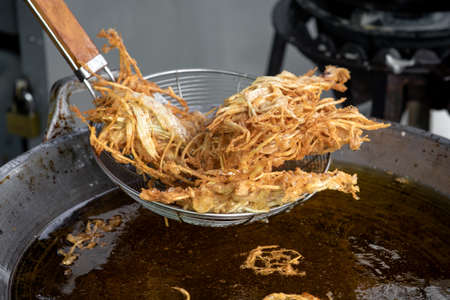 Frying shredded taro in hot oil. Cooking crispy shredded taro, vegetarian food.の写真素材