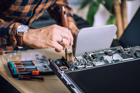 Technician cleaning the dust inside the old computer. Computer service and repair concept.の写真素材