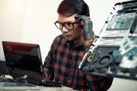Technician reparing a broken computer. Computer service and repair concept.