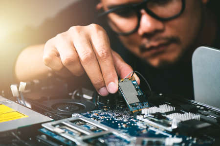 Technician reparing a broken computer. Computer service and repair concept.