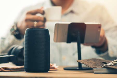 The man streams music from smartphone to speaker.の写真素材