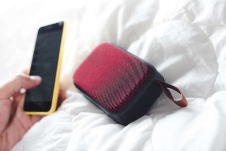 relaxing concept, Using wireless portable speaker on the bed.の写真素材