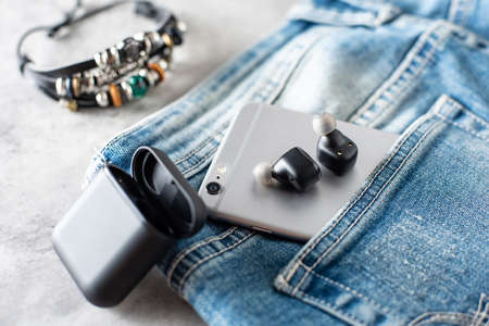 Pair of black true wireless earbuds with smartphone. Relaxation concept.の写真素材