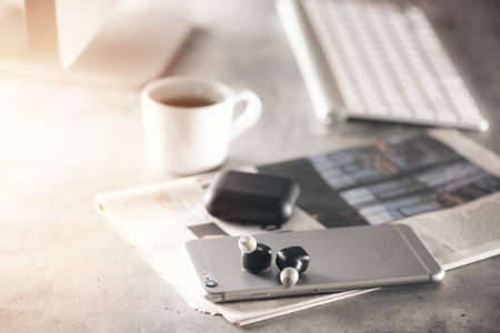 Pair of black true wireless earbuds with smartphone. Relaxation concept.の写真素材