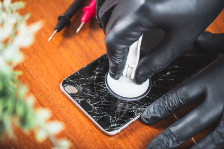 Technician reparing the broken smart phone with cracked screen.の写真素材
