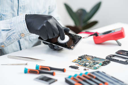 Technician reparing the broken smart phone with cracked screen.の写真素材