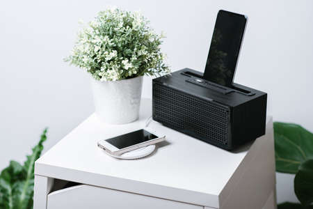 Charging the smartphone with wireless charger on the desk. Modern lifestyle concept.の写真素材