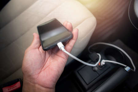 Charging smartphone battery with usb charger in the car.の写真素材
