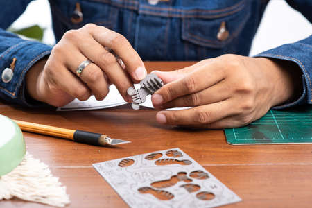 Assembling small cardboard model, the small cardboard parts are made with laser cutting technology....