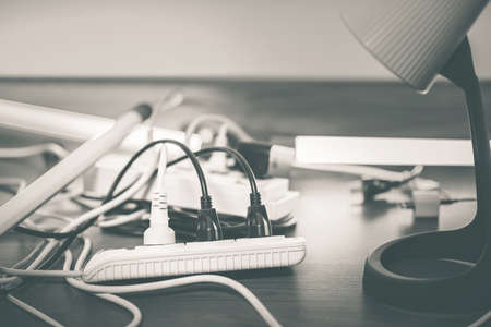 Many plugs connected to the power strip with individual switches.の写真素材