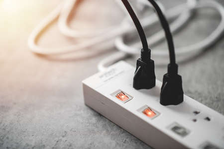 Many plugs connected to the power strip with individual switches.の写真素材