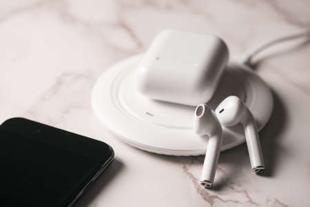 Pair of white wireless earbuds for smartphone. Relaxation concept.の写真素材