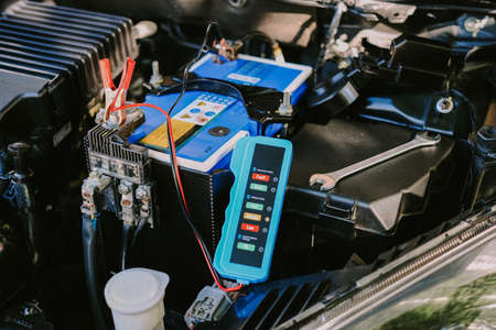 Checking a car battery level with car battery checker, car repairing conceptの写真素材