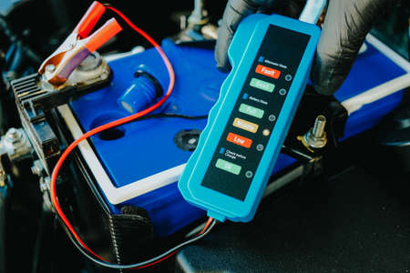 Checking a car battery level with car battery checker, car repairing conceptの写真素材
